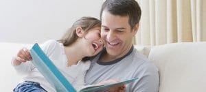father reading book to daughter